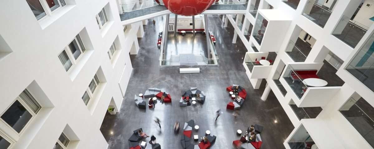 Students moving around the atrium area of modern university
