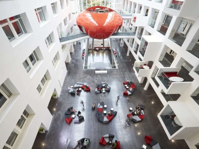 Students moving around the atrium area of modern university