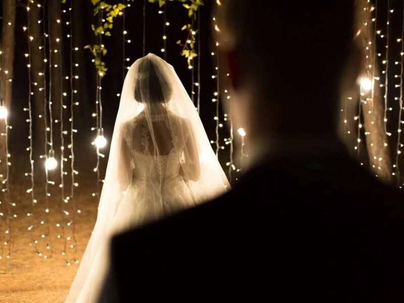Wedding ceremony night. Meeting of the newlyweds, the bride and groom in the coniferous pine forest of candles and light bulbs.